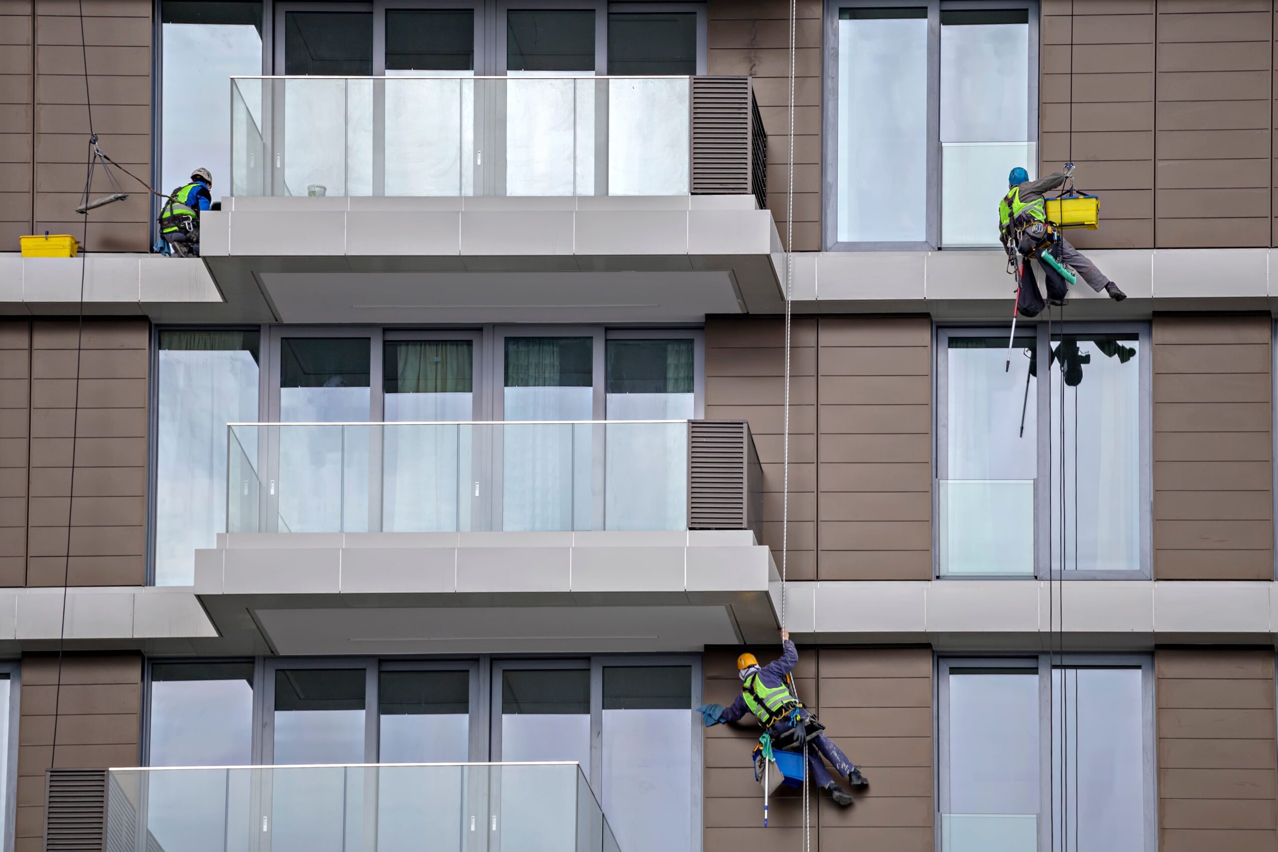 worker-using-rope-to-clean-a-high-apartment-buildi-2026-01-11-09-31-56-utc